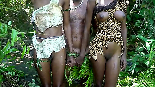 Two dark-skinned African tribe girls please the village chief in the forest